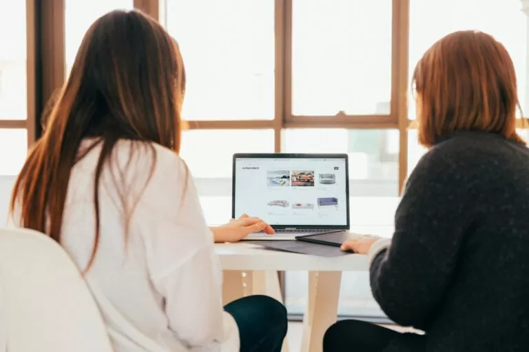 Two women are viewing a computer.