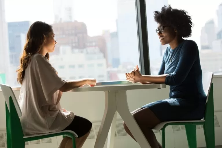 Two employees communicating at the table.